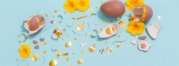 Velikonoční Čokoládové Vejce Zlatými Konfety Jarní Květiny Modrém Pozadí — Stock fotografie