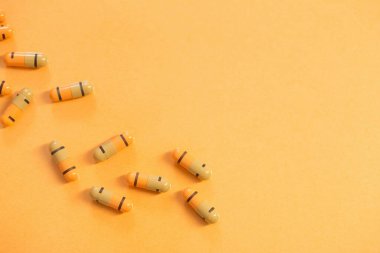 Turuncu arka planda ilaçlar ve haplar