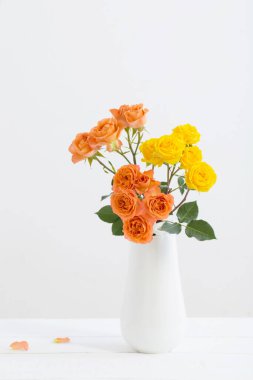 Beyaz arkaplanda beyaz vazodaki güller