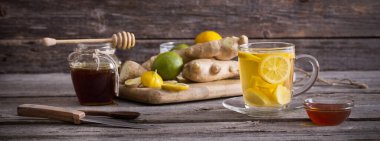 Ginger çayı ve malzemeler ahşap bir arka planda.