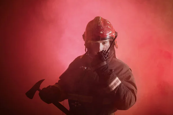 深红色背景下身着制服的消防员画像 — 图库照片