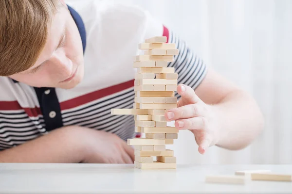 Young Man Builds Tower Wooden Cubes — Stock Photo, Image