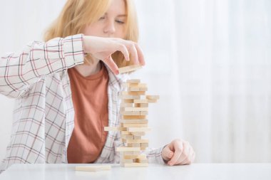 Güzel genç kız ahşap küplerden kule yapıyor.