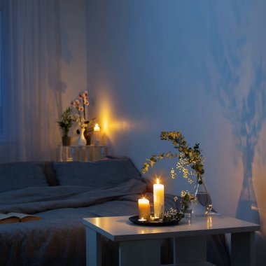 Yatak odasının içi çiçekler ve yanan mumlarla dolu.