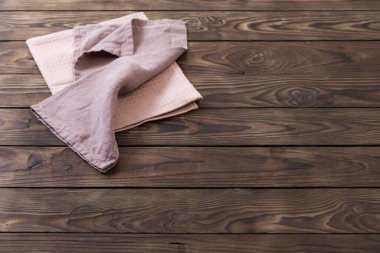 Koyu ahşap masada keten peçete.