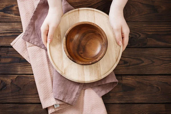 旧木桌上的女性手和木制盘子 — 图库照片