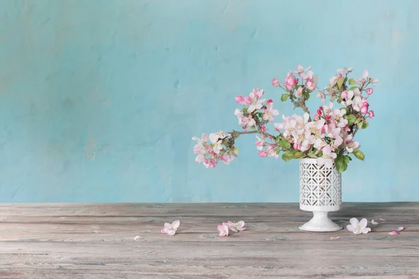 蓝色的旧墙上花瓶里有粉红色的苹果花 — 图库照片