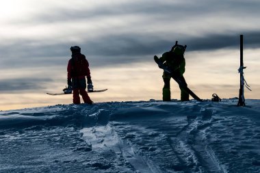 Dağ tepe üzerinde iki snowboard düşkünleri siluetleri