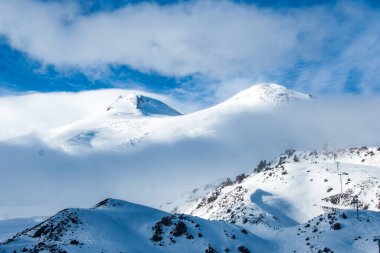 Elbrus Dağı bulutların üzerinde güneş ışığında. Kafkas dağları kış manzarası