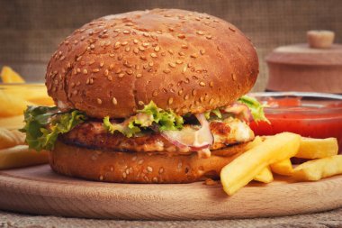 Ahşap tabak portre üzerinde domates soslu tavuk burger