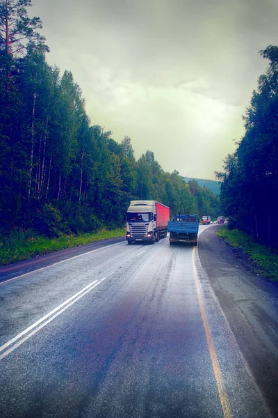 Russia, Ufa - July 27, 2016: lorry on highway-delivery of goods in bad weather threat. photo from the cab of a large truck on top — Stock Photo, Image