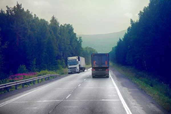 Rosja, Ufa - 27 lipca 2016: ciężarówki na autostradzie dostawy towarów w złą pogodę zagrożenie. Zdjęcie z kabiny dużych ciężarówek na górze — Zdjęcie stockowe