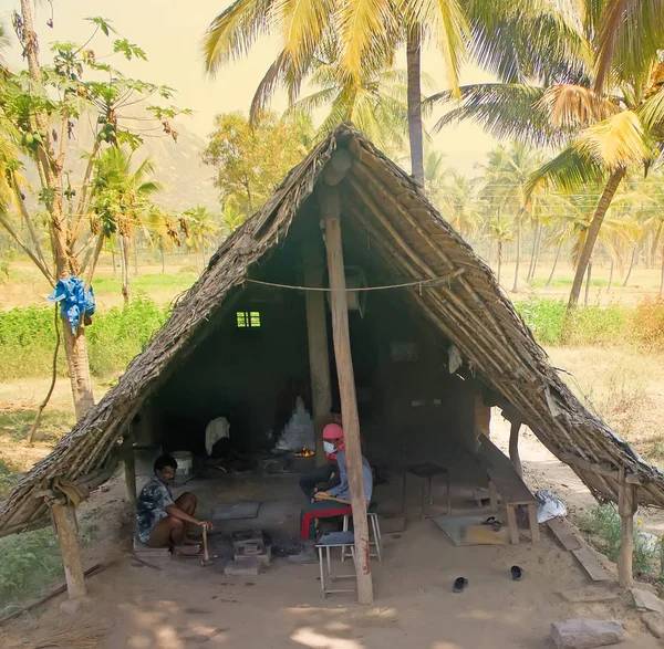 Życie w Indiach. Prymitywne wiejskiej kuźni w gaju palmowego drzewa i kowali z narzędzia — Zdjęcie stockowe