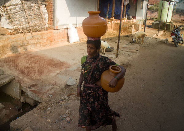 Indian life. Woman with clay jugs (amphora, one on head), water carrier