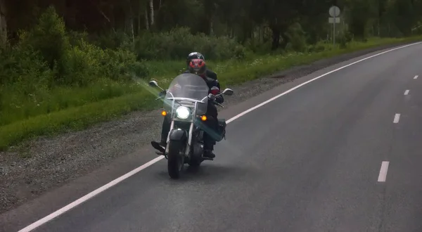 Biker reis in schemering op snelweg — Stockfoto