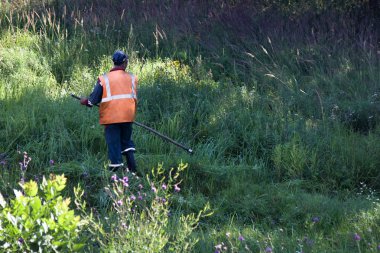 Eski moda el ile biçme içinde yol kenarında çimlere yol işçisi mows
