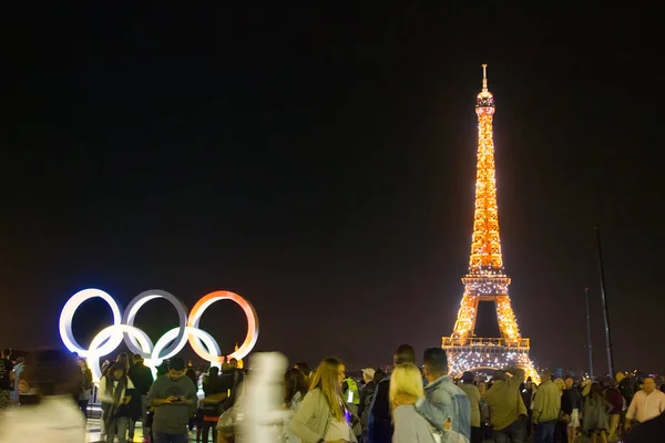 Wieża Eiffla, turyści w godzinach nocnych i symbole olimpijskie — Zdjęcie stockowe