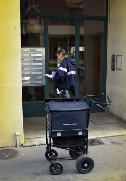 Postbode (de postwoman, drager van de brief van de vrouw) met mail bag — Stockfoto