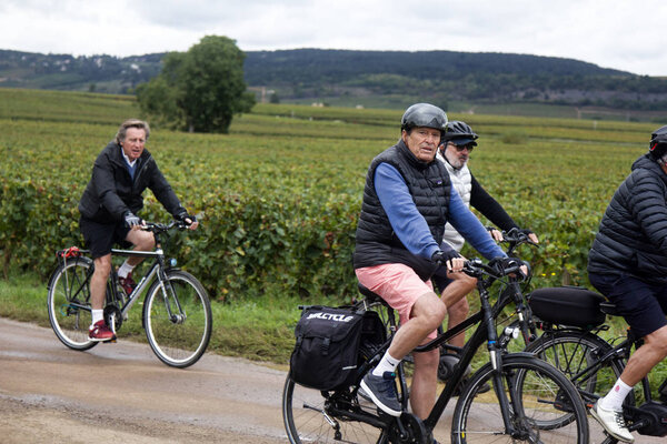 Cycling tour through fields at countryside of respectable cyclists