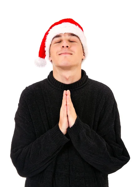 Młody człowiek w Santa Hat modląc się — Zdjęcie stockowe