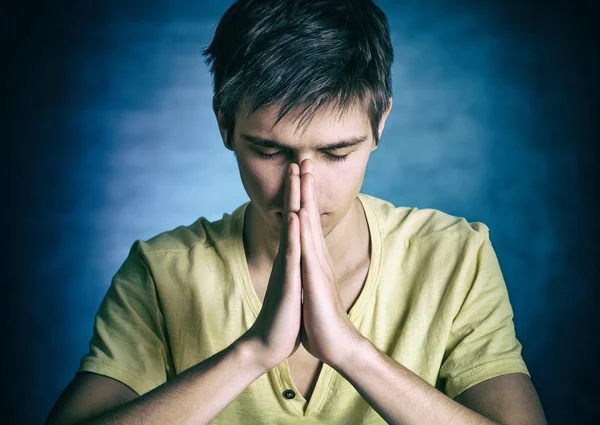 Молодой человек молится — стоковое фото
