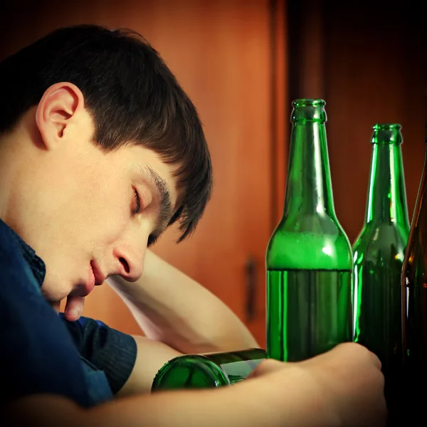 Молодой человек спит с пивом — стоковое фото