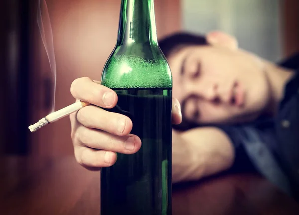 Young Man slapen met het bier Stockafbeelding