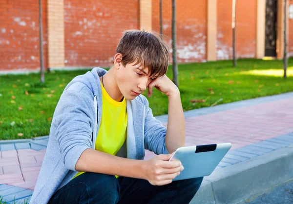 Trauriger Teenager mit Tablet — Stockfoto