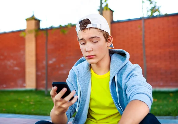 Adolescente triste com um telefone — Fotografia de Stock