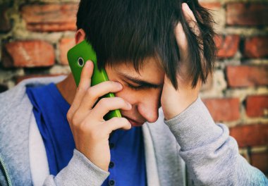 Üzgün genç adam bir telefon ile