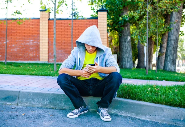 Грустный подросток с мобильником — стоковое фото