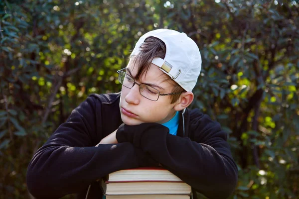 Грустный подросток с книгами — стоковое фото