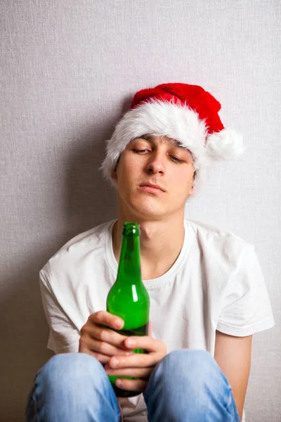 Trauriger junger Mann mit Weihnachtsmütze — Stockfoto