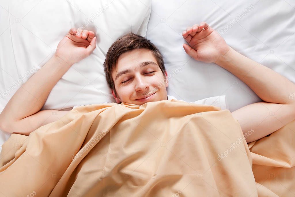 Happy Young Man sleep in the Bed at the Home
