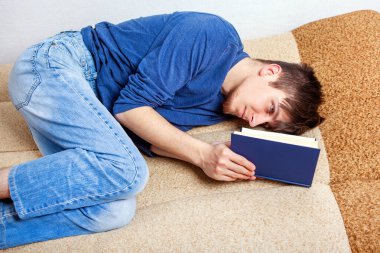 Genç adam evdeki kanepe üzerine bir kitap okudu.
