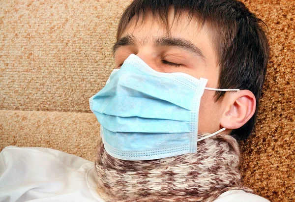 Kranker Junger Mann Mit Grippe Maske Auf Dem Sofa Heim — Stockfoto