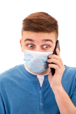 Grip Maskeli Genç Adam 'ı Beyaz Arkaplan' da izole edilmiş bir cep telefonuyla şok etti.