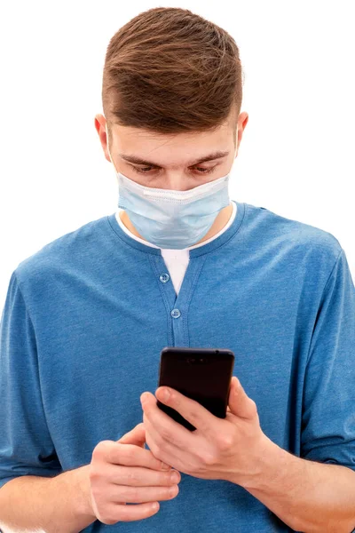 Junger Mann Mit Grippemaske Hält Sein Handy Isoliert Auf Weißem — Stockfoto