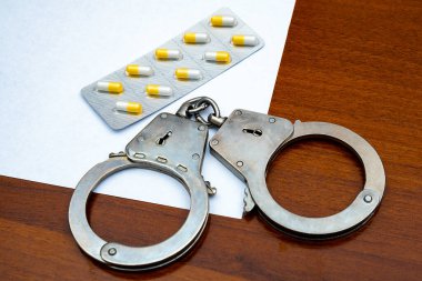 Tahta masada haplarla kelepçelenmiş. Yakın plan.