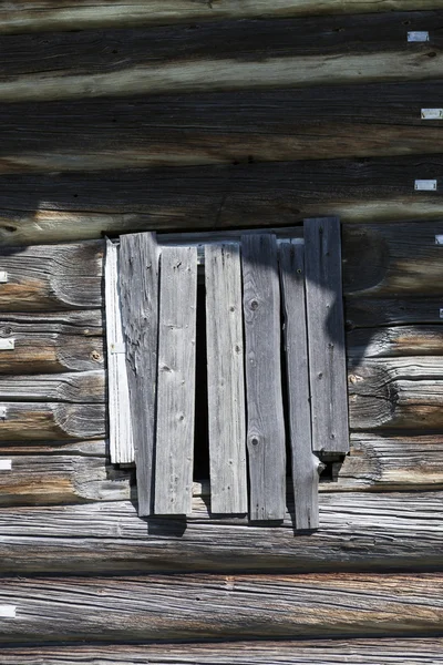 Oude venster gehamerd houten planken van een houten huis, een verlaten boerderij Rusland. Verstoring in het dorp, de verlaten nederzettingen. — Stockfoto