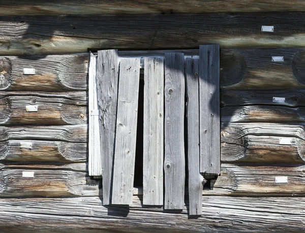 Oude venster gehamerd houten planken van een houten huis, een verlaten boerderij Rusland. Verstoring in het dorp, de verlaten nederzettingen. — Stockfoto
