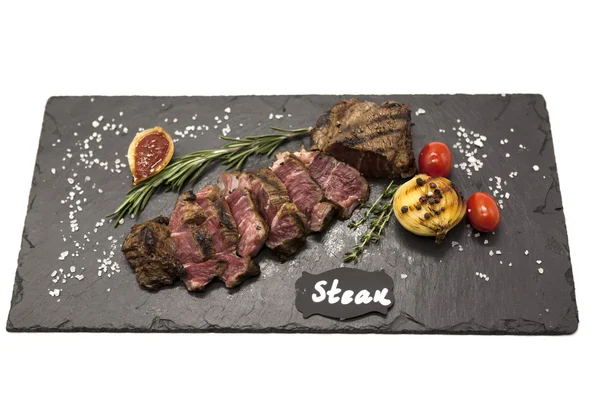 Grilled striploin steak on a stone plate baked potatoes and barbecue sauce. — Stock Photo, Image