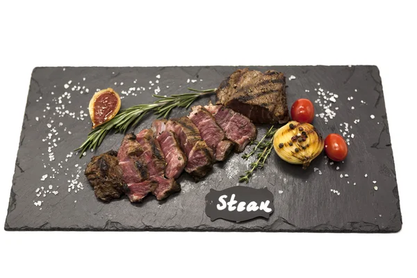 Striploin biftek pişmiş patates ve barbekü sosu bir taş plaka üzerinde ızgara. — Stok fotoğraf