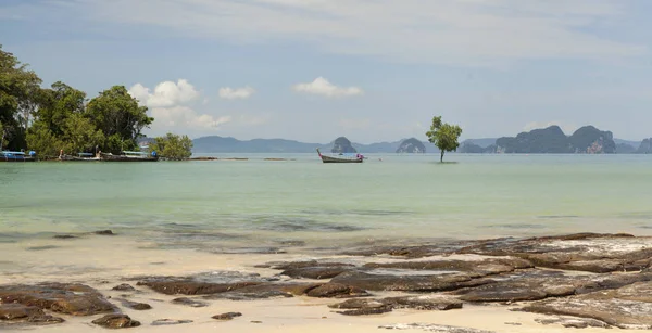 Praia bonita com vista para o mar e um barco de pesca tailandês tradicional.Praia bonita com árvores tropicais com uma onda do mar e céu azul com nuvens brancas. Tailândia. Phuket. . — Fotografia de Stock