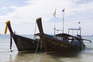 İki büyük geleneksel Tay tekne renkli kurdeleler ve bayrakları ile. Tayland Krabi