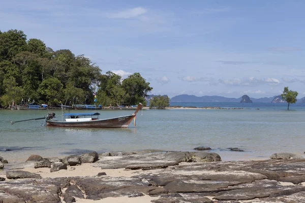Das Boot schwimmt auf dem Hintergrund der wunderschönen Insel. Traditionelle thailändische Fischerboote mit bunten Bändern und Fahnen. thailändische Krabi — Stockfoto