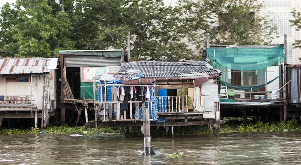 Oude hutjes, arme buurten op het water van de rivier. Thailand Bangkok. — Stockfoto