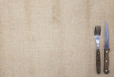 Arka plan için belgili tanımlık yemek listesi. Masa örtüsü çuval bezi, çatal, bıçak biftek ve peçete. Biftek Restoran için bir menü oluşturmak için kullanılır.