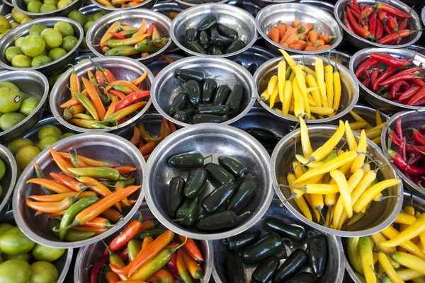 Καυτές πιπεριές διάφορες ποικιλίες είναι οι πλάκες στην αγορά μετρητής. Χιλή πιπεριά, πιπέρι καγιέν, πικάντικο μπουκέτο με πιπεριά, κινεζική πιπέρι. Μεγάλη φωτογραφία για τους πωλητές των λαχανικών. — Φωτογραφία Αρχείου
