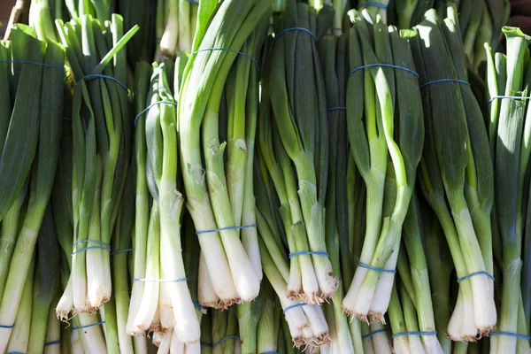Green onions, fresh bundles lay on the counter of a village market. — Stock Photo, Image